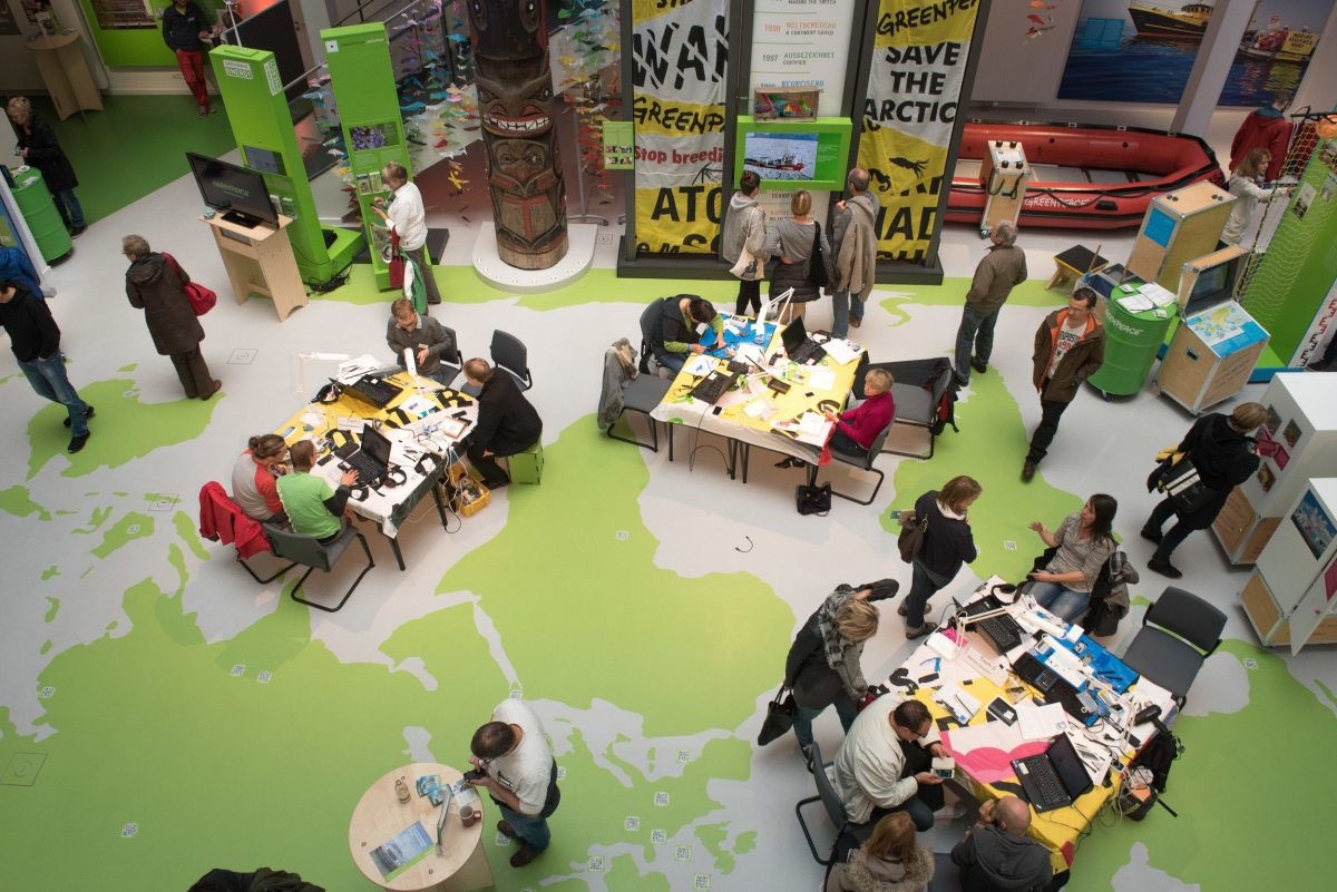 Konzentrierte Atmosphäre im Atrium des Greenpeace-Büros in Hamburg: Im Repair Café können – unter fachlicher Anleitung – defekte Geräte repariert werden. Zusätzlich gibt es eine Ausstellung zu den Themen Elektroschrott und Grüne Elektronik und mehrere Vorträge.