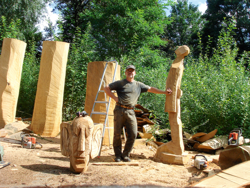  Förderer und Bildhauer Bernd Moenikes inmitten seiner Holzfiguren. Die filigrane Bronzeskulptur (oben) symbolisiert den Klimawandel
