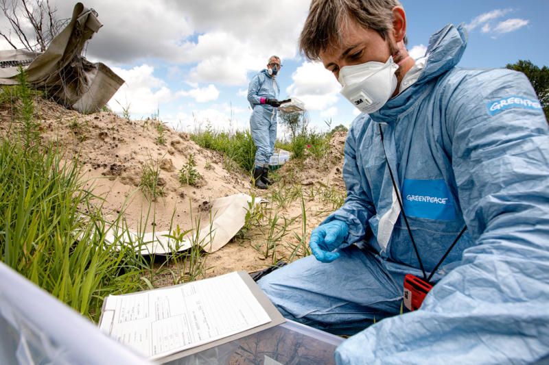 In der Nähe von militärischen Unterständen nimmt das Greenpeace-Team Boden­proben, die vor Ort im mobilen Labor untersucht werden