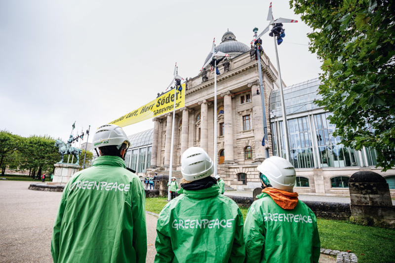 Masten zu Windkrafträdern – zusätzlich installierten Greenpeace-Aktive in München einen Windradzähler, der leider die meiste Zeit stillsteht