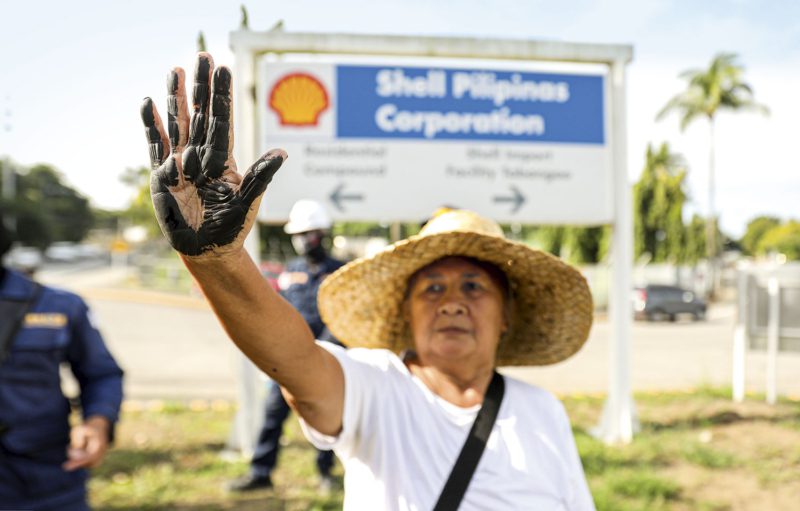 Protest mit ölverschmierter Hand: In Manila forderten Menschen Shell auf, Verantwortung zu übernehmen